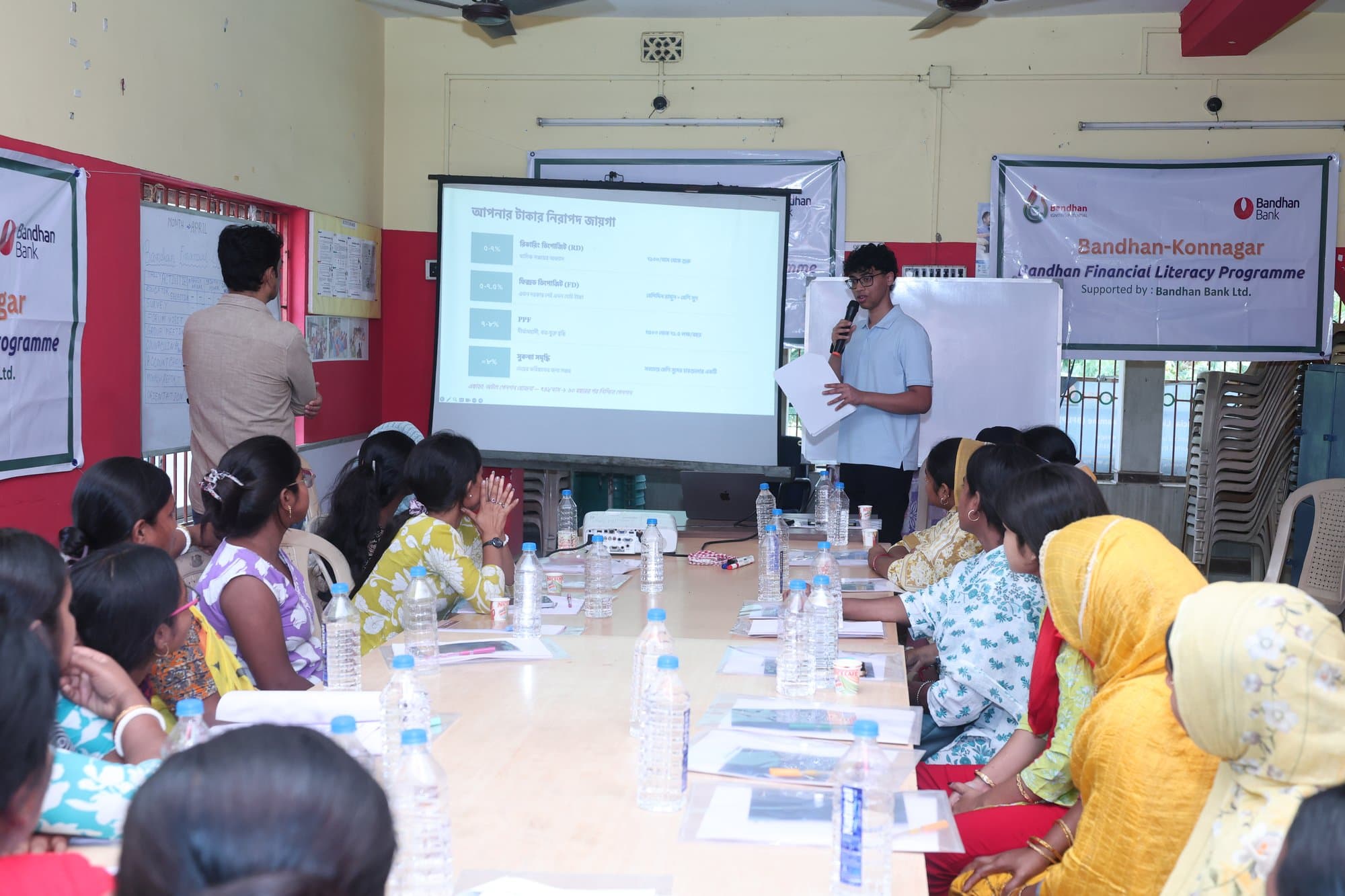 A wide view of the cohort in colourful saris during a workshop