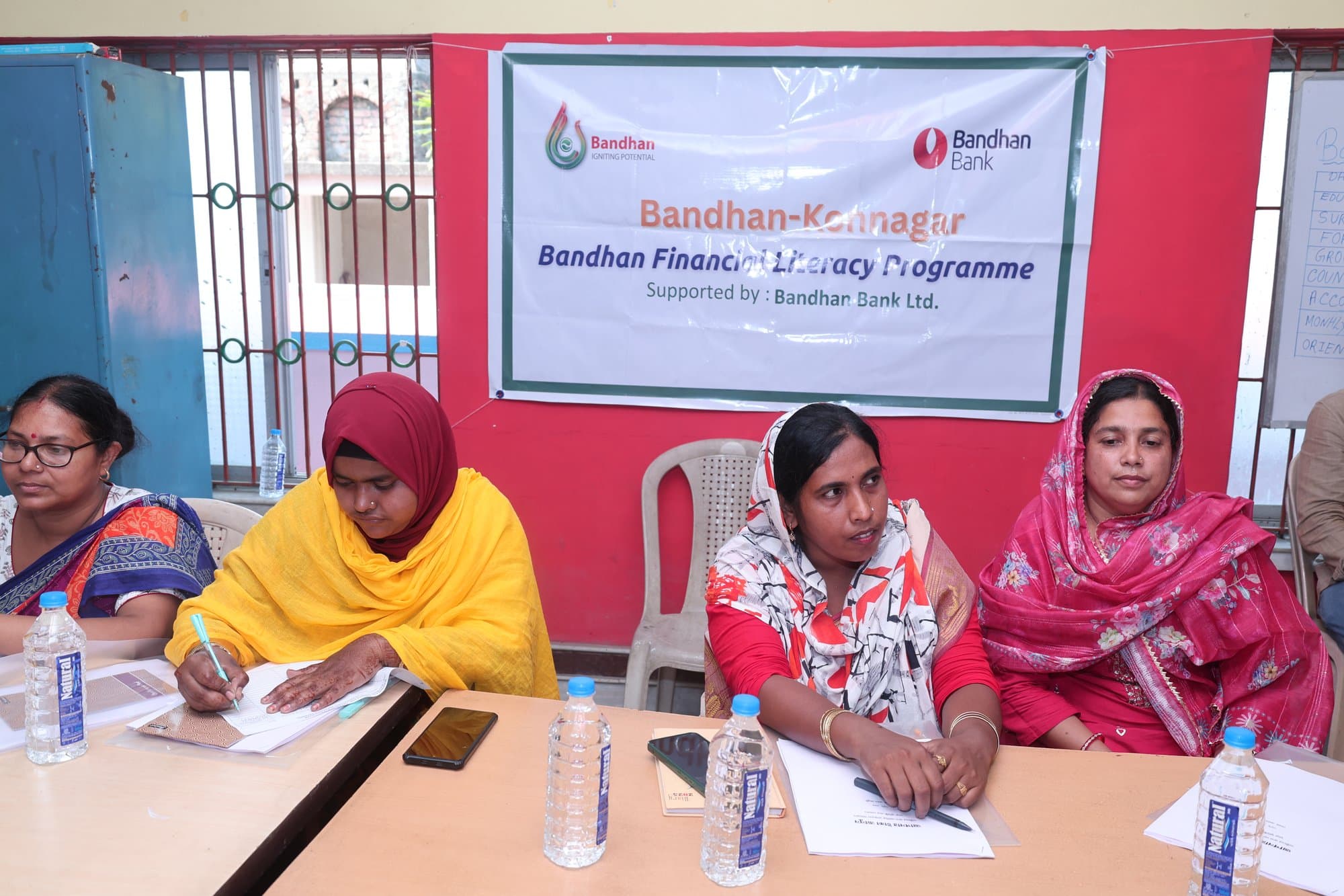 Participants writing notes under the programme banner