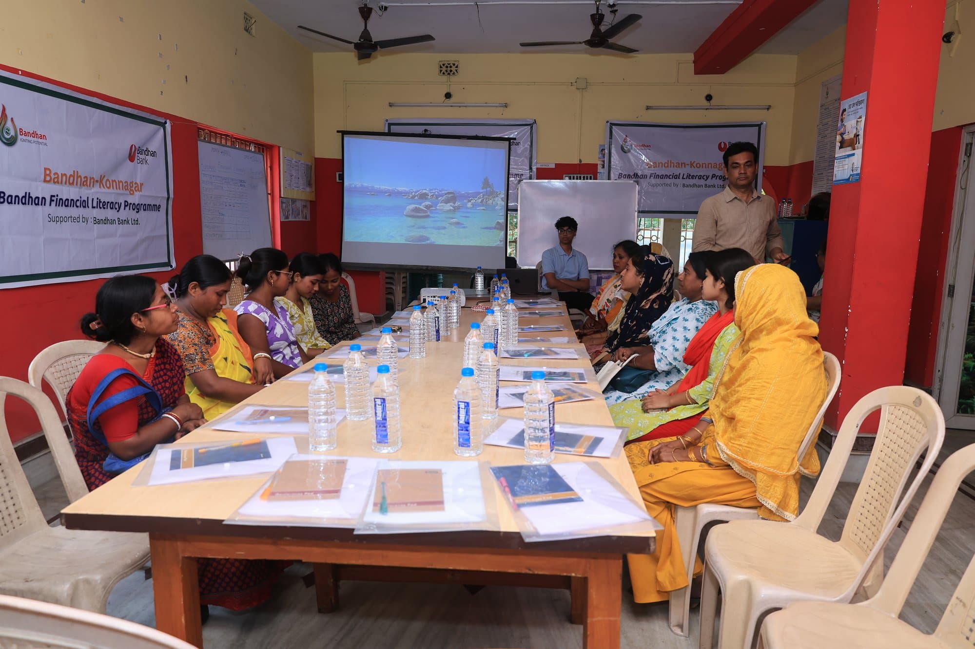 Women seated around long tables at a Knowing Your Money workshop