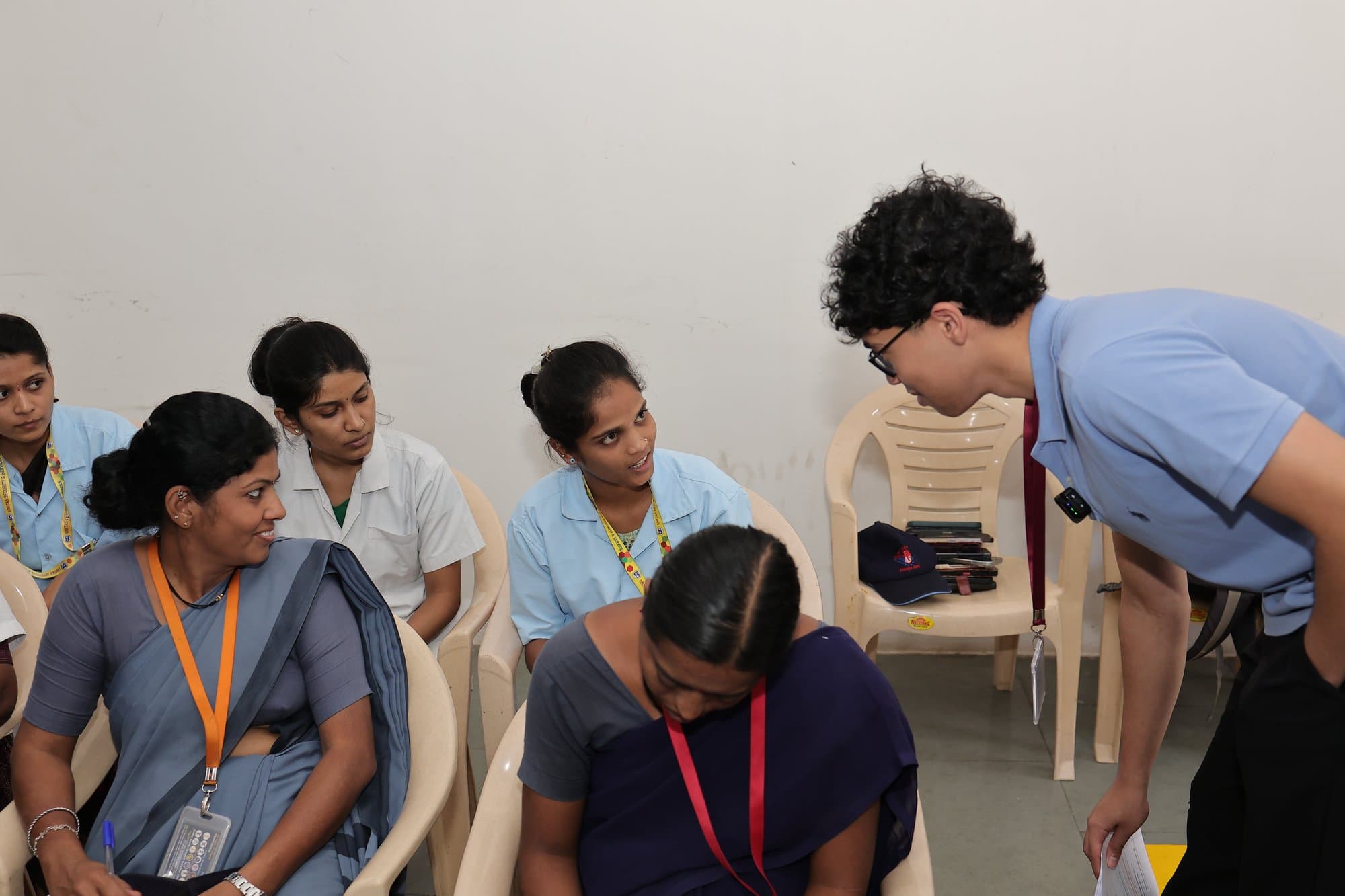 The founder crouching to talk with participants in Kolhapur