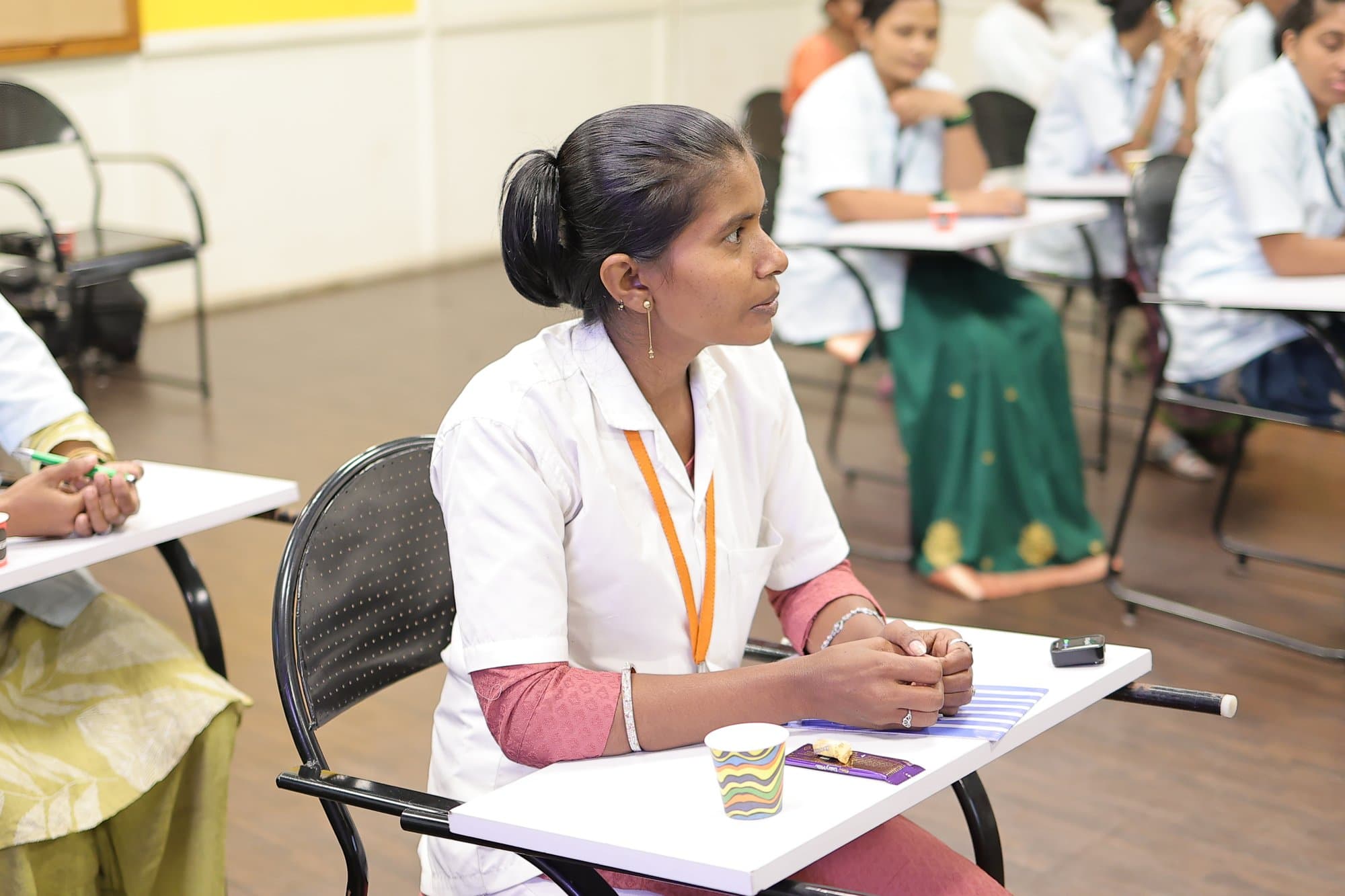 A participant in Kolhapur at her desk, listening
