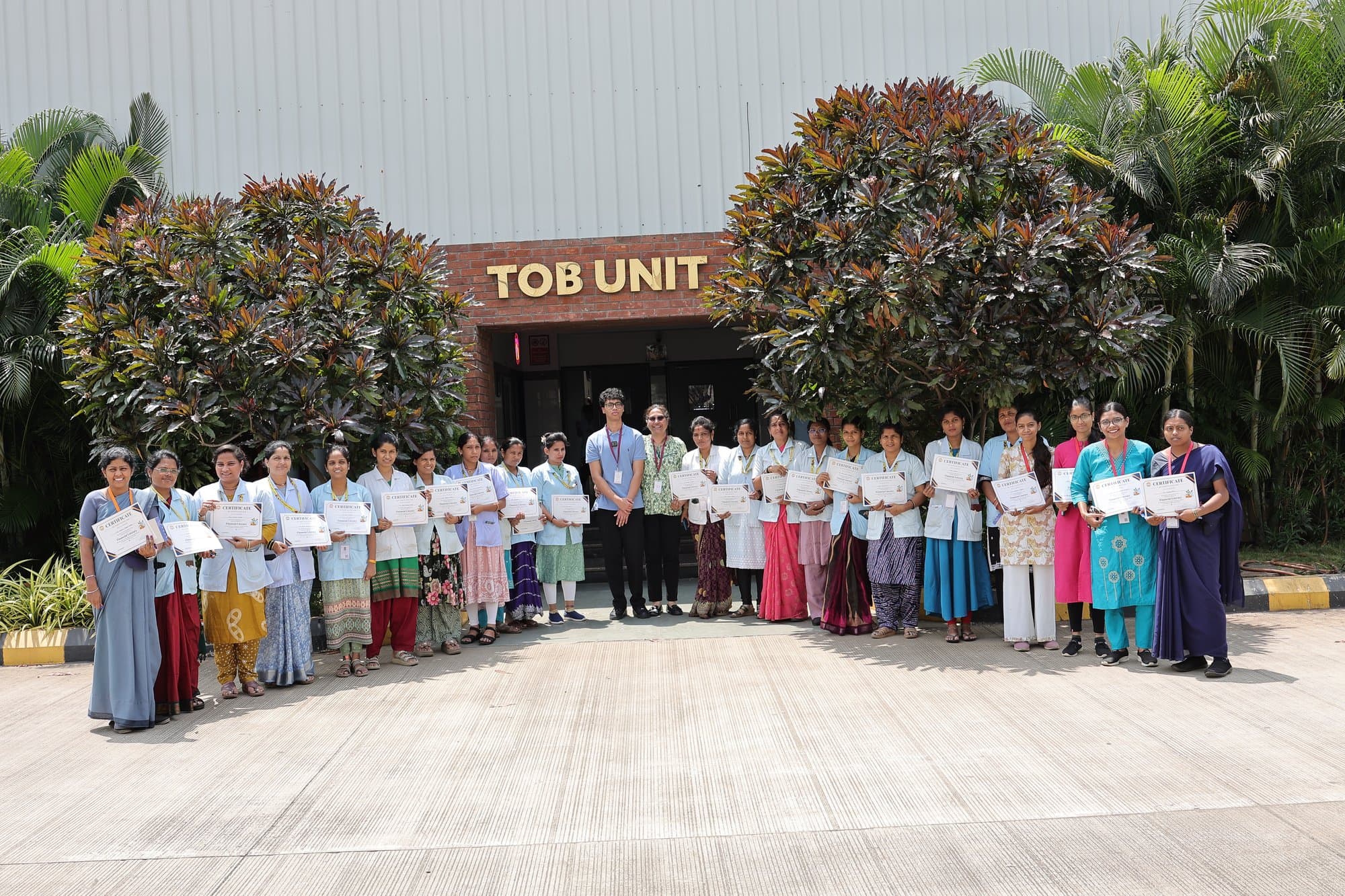 A group with their certificates outside the unit where they work