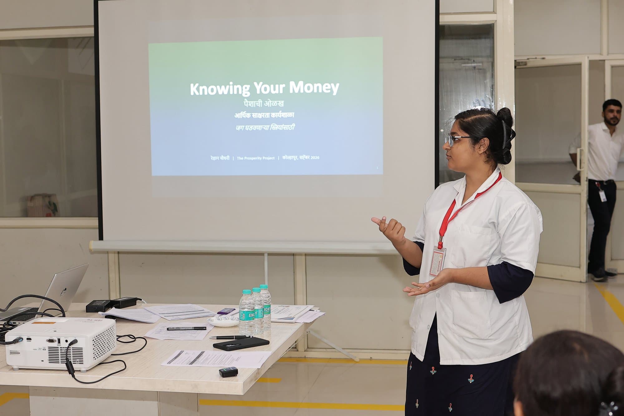 A participant standing beside the projected title slide at the start of a session